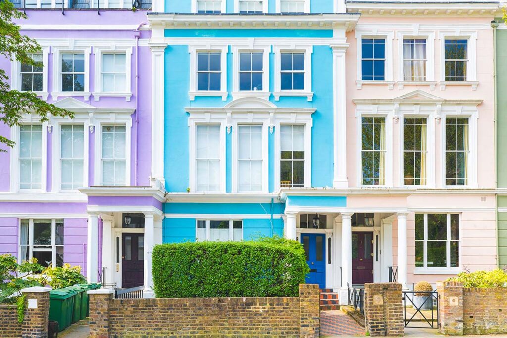 Colorful row of houses in London on a sunny day - Beatiful architecture scene in UK capital city near Regents Park - Close up view of three houses with purple, light blue and pink colors